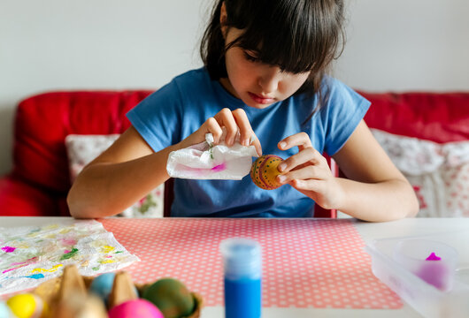 Little girl decorating Easter eggs