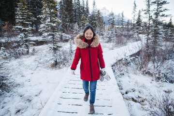 Young woman outside in winter wearing red coat and holding figur