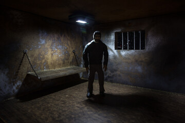 Obraz premium Jail or prison cell. Man in prison man behind bars concept. Old dirty grunge prison miniature. Dark prison interior creative decoration. Selective focus