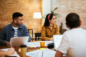 Modern freelance colleagues having meeting in loft workspace