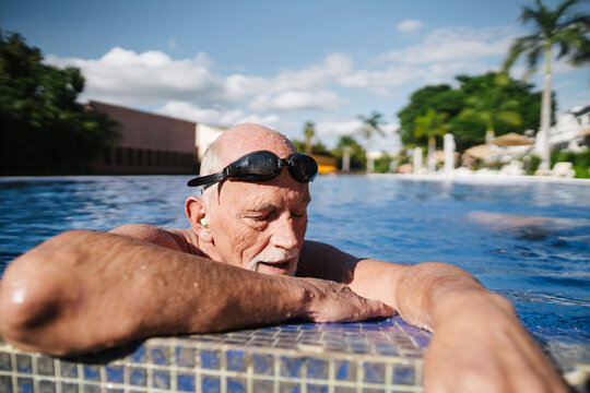 Healthy, retirement-age man breathing hard in the pool.