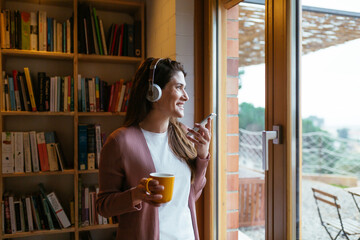 Woman recording audio message near window