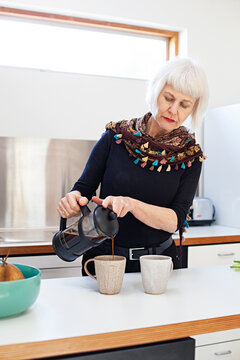 senior woman in kitchen making coffee