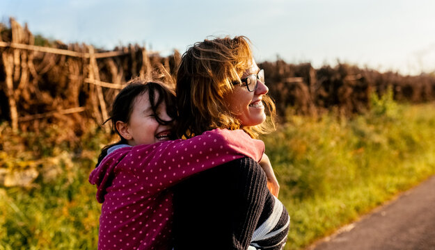 daughter riding her mother's piggyback