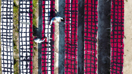 Indonesia August 7 2020 : White fabric hanging to dry before drawing batik process. Hanging Batik