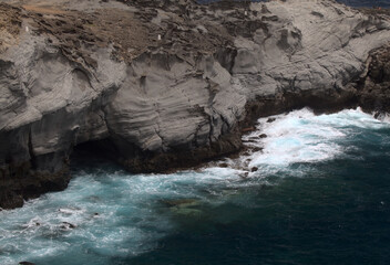 North coast of Gran Canaria, Canary Islands, Banaderos area, waves are breaking against elevated rock 
with salt evaporation ponds Salinas de Bufadero