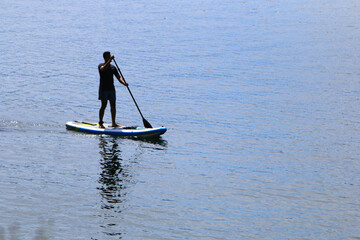 Fototapeta na wymiar Paddle boarding in mountain lake 