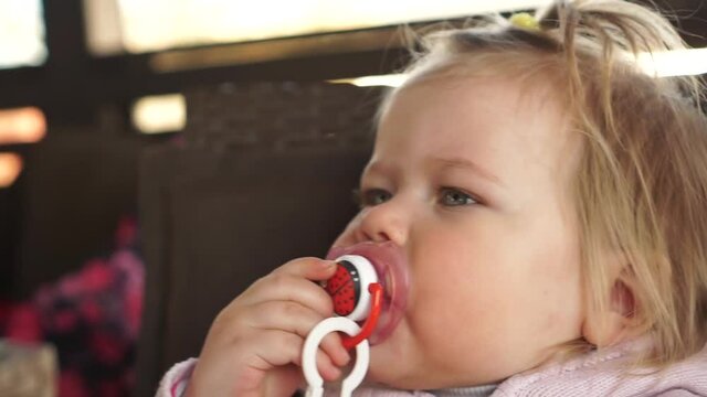 Little baby girl takes pacifier nipple and fell asleep immeadiately. Sleepy baby tired at the end of the day