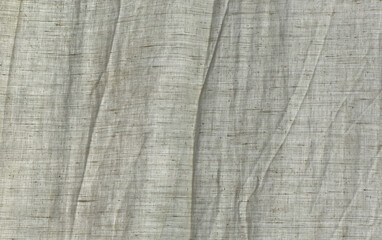 Curtain from crumpled natural cotton fabric on the window.