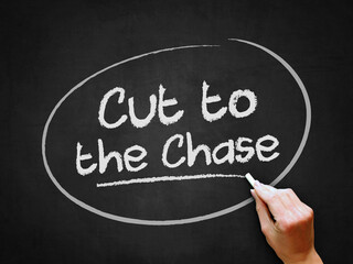 A hand writing 'Cut to the Chase' on chalkboard for straight forward meaning.