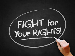 A hand writing 'Fight for Your Rights' on chalkboard for protesting or demonstrating to fight for...