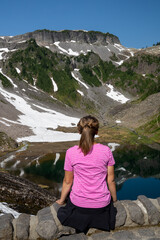 Naklejka premium Woman with back facing camera enjoys the view at Heather Meadows in Mt Baker National Recreation Area, Washington State