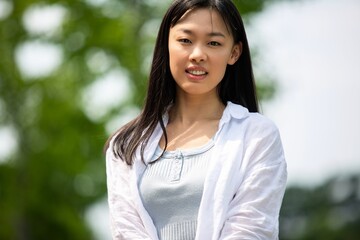 緑の中に立つ若い女性