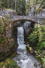 Fototapeta na wymiar Christine Falls in Mt Rainier National Park is a waterfall with a picturesque bridge