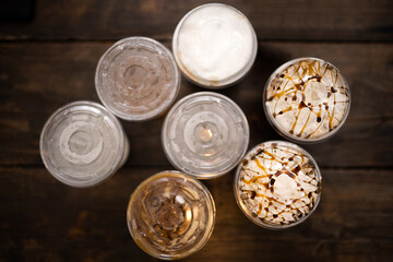 top view of cups with cold drinks on wood  background -concept of sweets drink