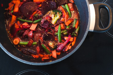 plant-based food, vegan beetroot and vegetables stir fry in pot getting cooked