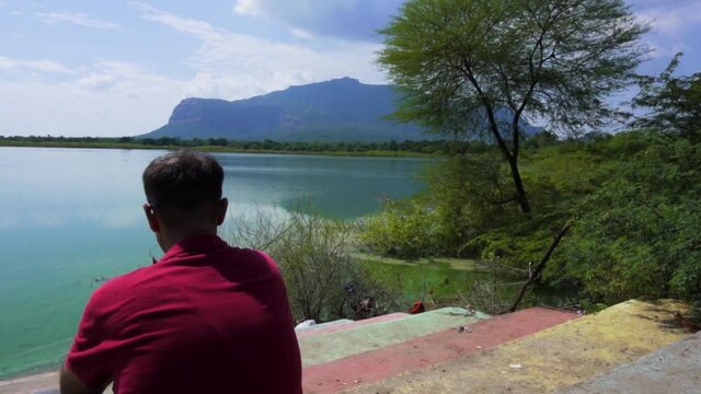 man at Vadatalav lake. man enjoying nature and pavagadh mountain