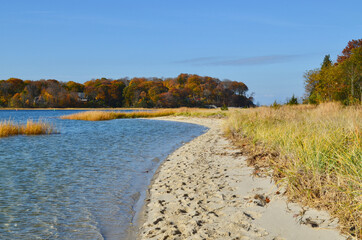 A sand beach near the mouth of a north shore Long Island harbor in fall.  Setauket Harbor, NY.  Copy space.