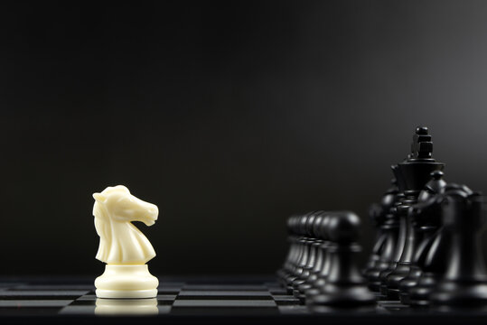 One White Knight Chess Piece Facing All Black Chess Pieces For Fierce Competition Situation, One Against Many Concept