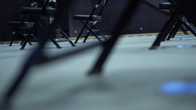 Foldable Black Chairs Placed 6ft Apart to Socially Distance Audience in an Empty Room