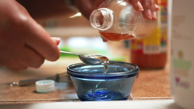 Measuring apple cider vinegar into a small glass bowl to add to a homemade recipe - slow motion