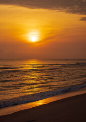 Obraz premium Ocean at dawn with the sun's golden orb against the background glow of sunrise.