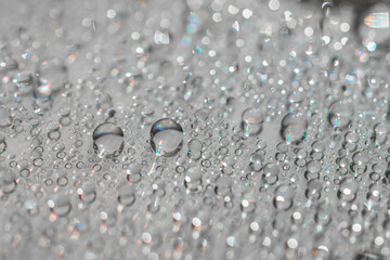 Macro photography of water drops on a mirror reflective surface