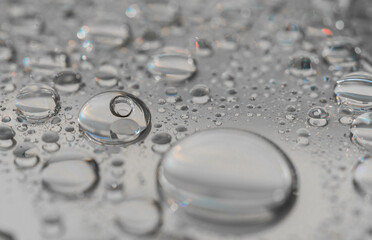 Macro photography of water drops on a mirror reflective surface. Concept of being different than the rest