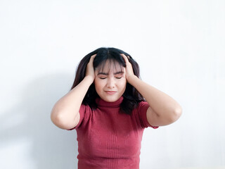 Portrait of a stressed young women holding head in hands with the background. Unhappy Asian girl with worried stressed face expression looking down.