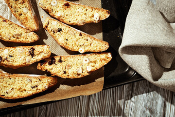 Italian biscotti cookies on black baking sheet. Fresh baked cookies with nuts and dried cranberries.