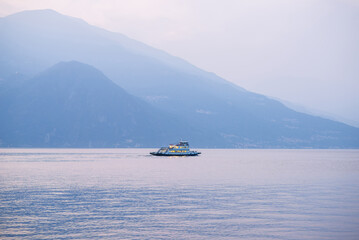 Sunset and Dusk on Lake Como. Italy. Lonely Ferry Floats on Calm Surface of Water.