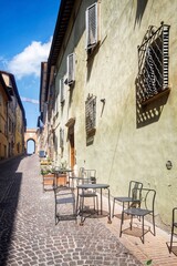 typical street in urbino with an ancient door of rhe medieval town in the background 