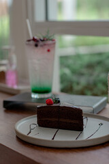 chocolate cake with raspberry topping on wood table in cafe.