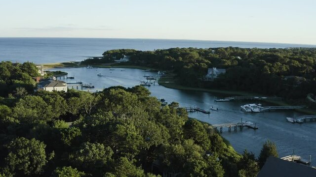 Beautiful aerial view of a private marina on the coast of Cape Cod with speedboats traveling down