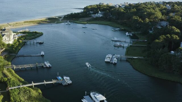 Aerial overhead shot of a beautiful private marina in Cape Cod with a speed boat passing by