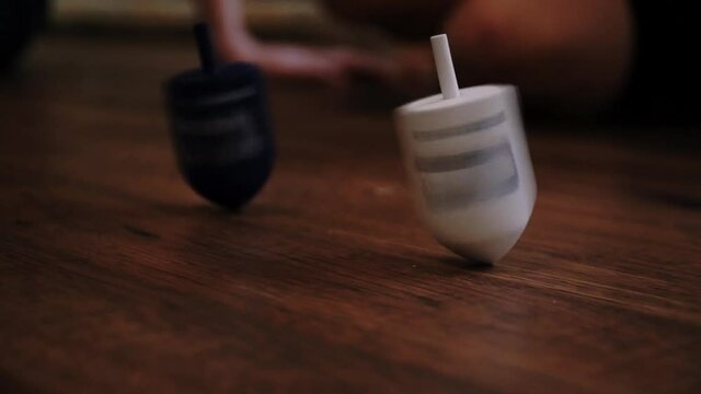 spinning the dreidel at hannukah party having fun jewish games before lighting the menorah