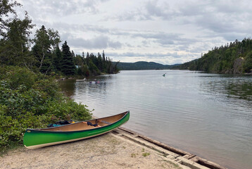 Canoe on shore and kayakers on the water in Pukaskwa National Park in nothern Ontario, Canada