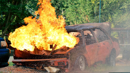 Firefighter fighting with flame using fire hose chemical water foam spray engine. Fireman wear hard...