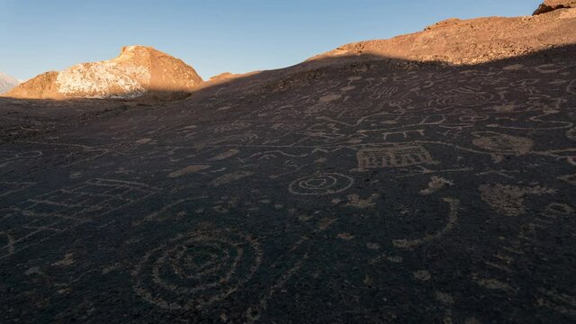Time lapse tracking shot of sun light revealing Native American rock art panel in California