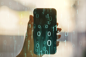 Creative abstract binary code hologram and hand with mobile phone on background, AI and machine learning concept. Multiexposure © Pixels Hunter