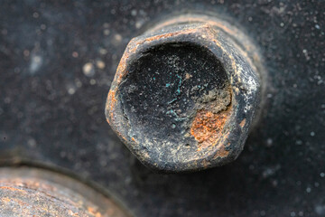 rusty black bolt on a metal plate