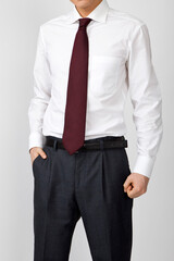 torso of businessman with hands in pockets