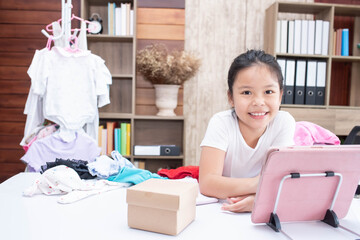 business child girl working online e-commerce shopping at her shop. kid seller prepare parcel box of product for deliver to customer. Online selling, e-commerce. doing business in her home..