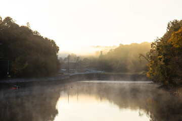 朝靄と日の出が映り込んでいる池
