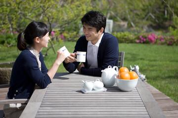 young couple sitting at desk drinking tea