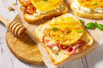 Healthy breakfast or snack, snacks. Toast with caramelized pineapple, bacon, nuts, and ricotta on the kitchen table.