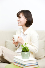 young woman sitting on sofa with teacup