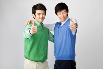 young men smiling with thumbs up sign