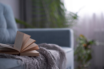 cozy living room with a turquoise sofa. book is lying on a sofa, the concept of a literary circle