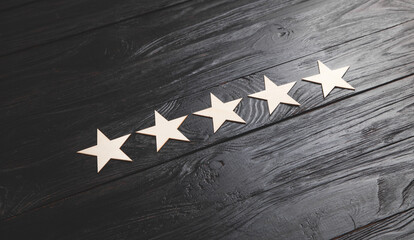 Wooden 5 stars on black background. Service rating